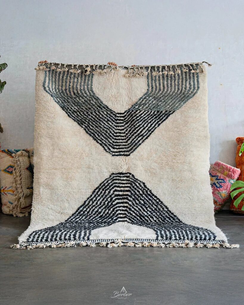 Authentic Beni Ourain rug with black geometric patterns on natural wool, handwoven in Morocco and displayed in a minimalist interior.