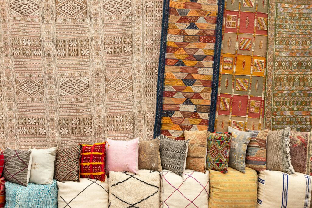 Moroccan decorative pillows and Berber rugs on display, featuring colorful patterns and traditional woven designs.