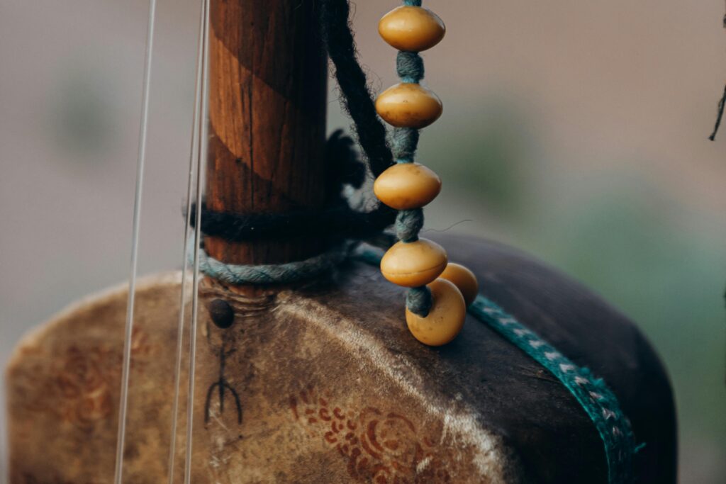 Close-up of a traditional Moroccan musical instrument with carved wood and decorative beads.