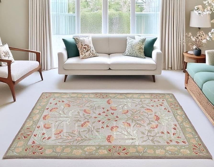 Living room featuring a traditional wool rug with floral patterns in soft green and beige tones, placed in front of a white sofa and large window.